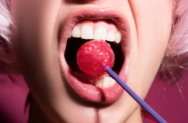 stock image Closeup female lips with pink lipgloss holding in mouth red lollipop candy. Lollipop on a face