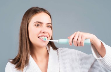 Young woman brushing teeth. Beautiful smile of young woman with healthy white teeth. Isolated background. Dental care. White tooth