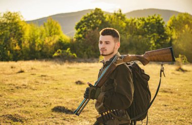 Avcı adam. Avcı bir sırt çantası ve bir av silahı. Av dönemi, sonbahar sezonu. Bir silah olan bir erkek. Avlanmayı bir avcı av silah ve av formu ile