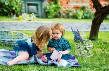 Korsanlık yapan çocuklar. Bahçede eğlenen beyaz bir çocuğun portresi. Sevimli çocuklar sever. Küçük kız parkta küçük oğlanı öpüyor. Bahçede yürürken yeşil çimenlikteki çocuk