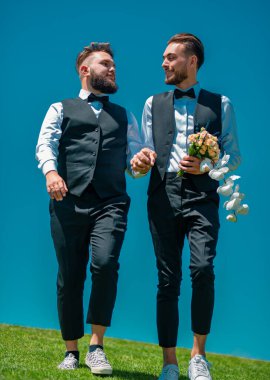 Eşcinsel çift düğünü. Mutlu eşcinsel çift yürüyor, el ele tutuşuyorlar. Sevgi dolu eşcinsel çift