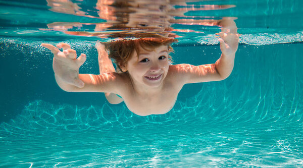 Funny face portrait of child boy swimming and diving underwater with fun in pool