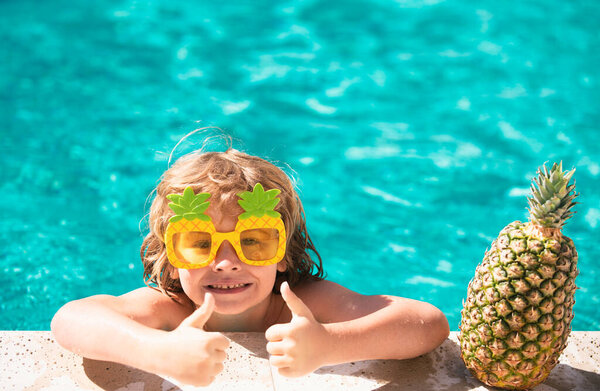 Child in swimming pool. Summer activity. Healthy kids lifestyle. Summer pineapple fruit