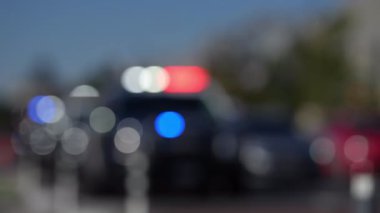 Bulanık ışık teşhircisi bir polis arabasının tepesinde. Amerikan Şehir Suçları. Polis ışıkları bulanık. Sokaktaki Amerikan polis arabası. Suç mahalli Bokeh. Cinayet hırsızlığından tutuklanmış. Acil durum sahnesi