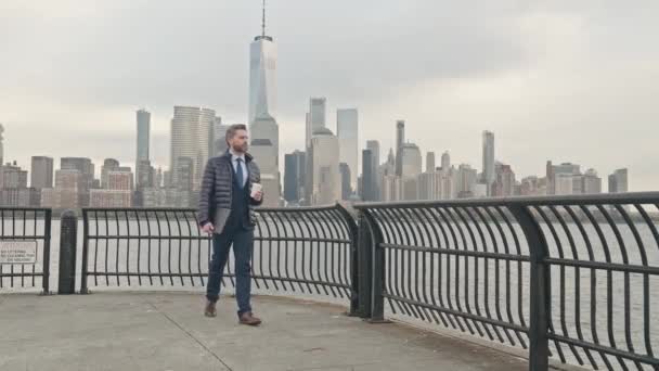 秋のジャケットの真剣なビジネスマンが外を歩いています ニューヨークの通りを歩くビジネスマン ニューヨーク市街地のビジネスススーツにひげを持つグレイビジネスマン マンハッタン ストリート近くのマネージャー — ストック動画