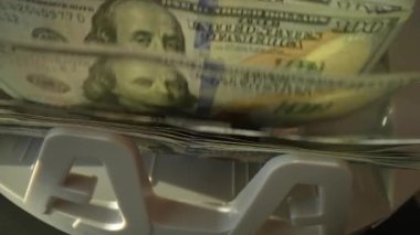 Kapatma para sayma makinesi dolar sayıyor. Ağır para sayma makinesi 100 dolarlık banknotları sayıyor. Para sayma makinesi. Finans bankacılığı kredi mevduat nakit