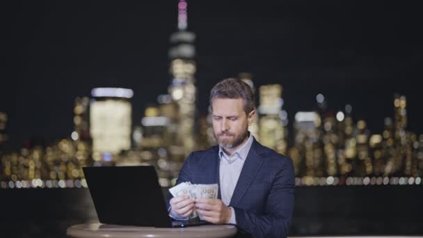 商人们用笔记本电脑在夜市的夜灯上数钱 穿着西装在街上数钱的人 在纽约市算我们的美元钞票钱美国的金融和银行业 — 图库视频影像