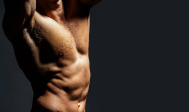 Seksi model vücut, çıplak gövde. Güçlü bir adam, baştan çıkarıcı bir eşcinsel. Kaslı, üstsüz, çekici bir adam. Üstsüz model. Stüdyoda çıplak eşcinsel pozu. Adam seksi görünüyor. Atletik kaslar
