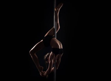 Direk dansı. Kolonda dans eden esnek seksi kız. Güzel esnek kadın vücudu. Siyah üzerine seksi esnek bir kadının moda stüdyosu portresi. Jimnastik ince ve esnek dansçı kadın