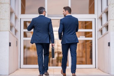 İş adamları toplantıda iletişim kuruyor. İki iş adamı iş görüşmesi sırasında dışarıda tartışıyorlar. İş adamları konuşuyor. İş ortakları dışarıda yürüyor. 40 'lı yılların işadamı sokakta yürüyor