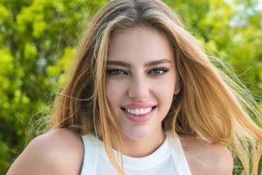 Gülen surat. Kadın yüzü mutlu bir gülümseme. Gülümseyen genç kızın yakın portresi. Dişleriyle gülümseyen, mutlu bir yüz ifadesiyle kameraya bakan genç bir kadın. Gülümseme. Gülen surat.