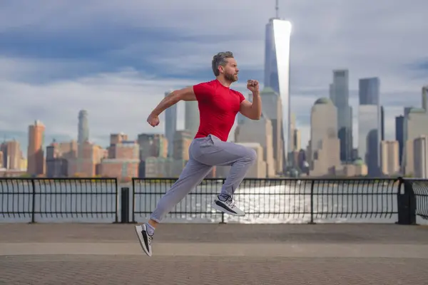 ランナー 通りでジョギングする男 成熟した男ランナーとフィットネススポーツモデルは ニューヨークのマンハッタンの近くで屋外でトレーニングします アウトドアスポーツトレーニングをしながら ミレニアルアスリートのジョギング — ストック写真