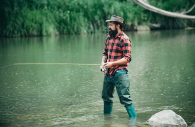 Balık tutan neşeli sakallı adamın portresi. Eğlen ve rahatla. Balık avlama maceraları. Hobi ve spor aktiviteleri. Tatildeki insan portresi. Balıkçı balıkçı ekipmanları. Yakışıklı adam dinleniyor.