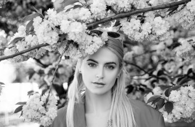 Bahar kızı. Çiçek açan ağacın yanında gülümseyen güzel bir kadın modelin açık hava portresi.