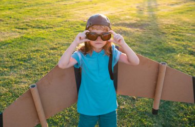 Çocuk çocuk oyuncak uçak kanatlarıyla oynuyor. Bir pilot olmayı hayal et. Süper kahraman uçuyor.
