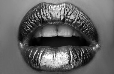 Şaşırtıcı duygular. Altın tasarım. Altın dudaklar, seksi dudaklarda altın ruj, metalik ağız. Güzel kadın makyajı. Yakın çekim.