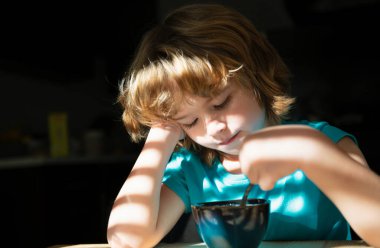 Çocuk kahvaltısını mutfakta yiyor. Çocukların beslenmesi. Çocuklar için sağlıklı yiyecekler. Organik ev yemekleri.