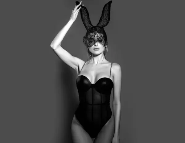 ウサギの耳を持つセクシーな女性 官能的な女性ポーズで素敵なドレスと黒ウサギのマスク — ストック写真