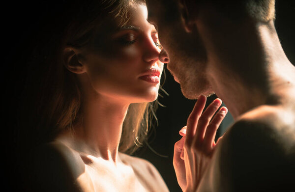 Couple in love going for the kiss. Close up face of a beautiful young couple in love embracing, romance and and affection