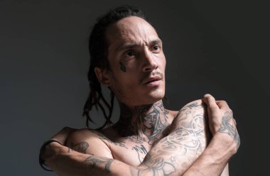 Acımasız adamın portresi. Ciddi yüzlü yakışıklı bir adamın portresi. Dövmeli ve zarif bir hippi. Hippi adam.