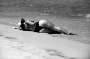 Summertime woman on beach. Sexy butt in bikini. Summer vacation on sea. Girl sunbath near ocean