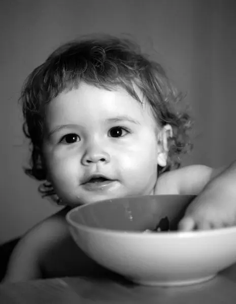 スプーンでかわいい白人の子供の肖像画 空腹乱雑な赤ちゃんとプレートを食べた後ピューレ — ストック写真