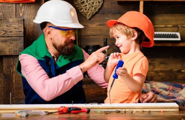 Alet yapımı. Babası küçük oğluna marangoz aletleri ve çekiç kullanmayı öğretiyor. Baba oğluna atölyede yardım ediyor.