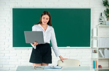 Lise öğrencisi sınıfta İngilizce ya da matematik öğreniyor. Bilgisayar teknolojisi olan kız öğrenci, uzaktan öğrenim