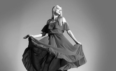 Gökyüzünde kırmızı elbiseli kadın hareketi. Moda elbiseli genç bir manken. Yazın moda kadını.