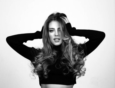 Moda elbiseli güzel bir kız stüdyo arka planında yalnız poz veriyor. Çok güzel bir kadın yüzü, örgü bluz giyiyor. Moda fotoğrafı.