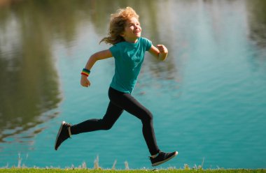 Çocuk dışarıda koşuyor. Çocuk yaz parkında koşuyor. Açık hava sporları ve çocuklar için spor, dışarıda egzersiz.