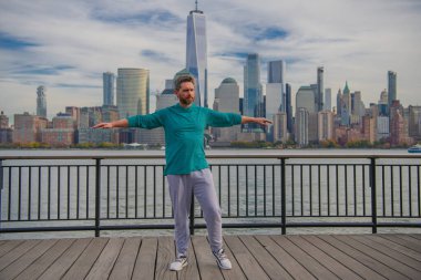 Spor formundaki adam New York 'ta spor yapıyor. Fitness adamı. Sporcu, kardiyo için antrenman yapıyor. Spor salonu açık havada. Adam dışarıda çalışıyor. New York parkında aktif yaşam tarzını seven bir adam.