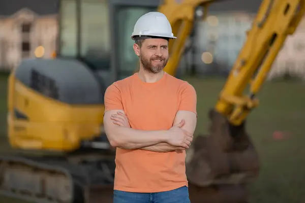 Builder man at building site. Construction manager in helmet. Male construction engineer. Architect at a construction site. Handyman builder in hardhat. Building concept. Builder foreman