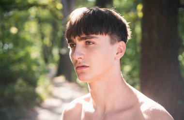 Dışarıda ciddi bir genç adam var. Erkek güzellik konsepti. Şık saç kesimi, saç stili. Kendine güveni olan yakışıklı adam.