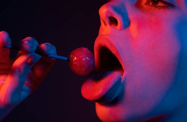 Lolipop yalayan baştan çıkarıcı kadın, sanat afişi, lolipoplu kırmızı dudaklar. Lolli pop ile seksi kırmızı kadın ağzı ve dili. Neon ışıkların tasarımı için sanat baskısı. Gece kulübü geçmişi