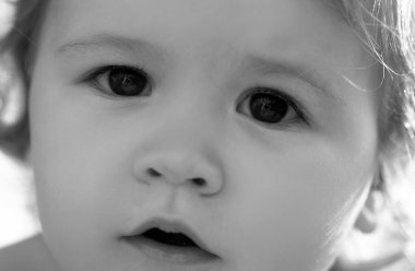 Kırpılmış yüzlü, küçük sarışın bir erkek bebeğin yakın portresi. Komik çocuk suratı