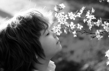 Çiçek açan ağaçlı bahar çocuğu. Çiçek bahçesindeki sevimli çocuk.