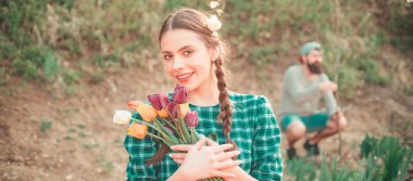 Bahar kadını pankarta karşı. Çiçek saksısı yapan neşeli genç bir kadın. Bahçe konsepti