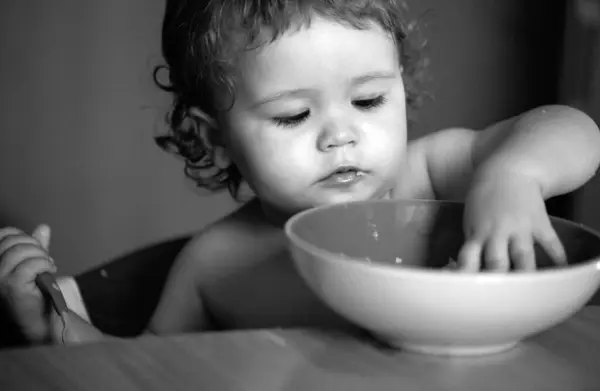 子供の赤ちゃんは料理とスプーンでキッチンでスープを食べる — ストック写真