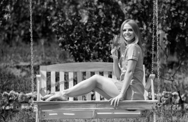 Şarap ya da üzüm suyu içen genç bir kadın. Beyaz üzümden yapılmış el yapımı şarap. Tahta salıncakta oturan mutlu hippi kız.