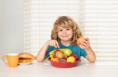 Kid eating apple. Healthy nutrition for children. Cute boy enjoy eating for morning breakfast with appetite. Hungry child eat tasty fruits and vegetables