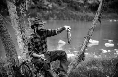 Genç sakallı adam gölde ya da nehirde balık tutuyor. Sinek avı