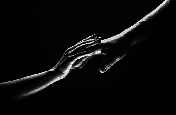 Two hands at the moment of farewell. The holding hands of relations. Help friend through a tough time. Rescue gesture, support, friendship and salvation concept. Man and woman holding hands