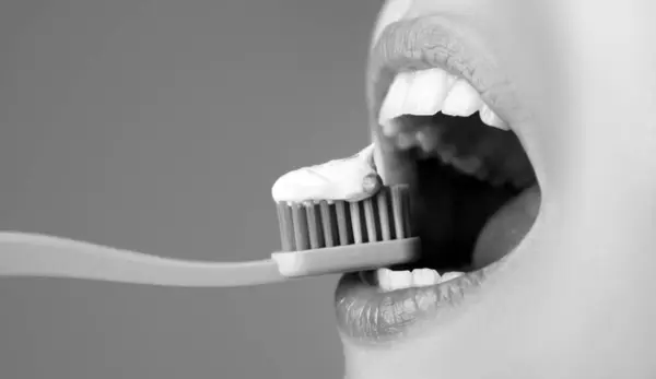 Brushing teeth close up. Woman with toothbrush closeup. Dental Care