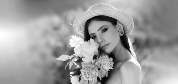 Outdoor fashion photo of beautiful young woman surrounded by spring flowers. Freedom lifestyle springtime concept. Banner for header website design, copy space