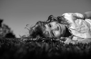 Çocuk çim tarlasında eğleniyor ve hayal kuruyor