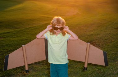 Pilot gözlüklü çocuk uçakla uçan mukavva kanat ustası. Rüya, hayal gücü, çocukluk. Seyahat ve çocuklar yaz tatili