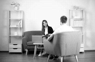 İki yaratıcı işçi ofiste projeyi tartışıyor. İş arkadaşları dizüstü bilgisayar kullanıyor