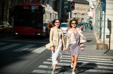 Çıkan arkadaşlar yaya geçidinde koşan kızlar, Summer Street City 'de birlikte harika vakit geçiriyorlar.
