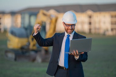 İnşaat mühendisi ya da inşaat mühendisi. İnşaat alanında kask ve takım elbiseli mühendis. Kazıcının yanındaki inşaat müdürü. Yenileme konsepti